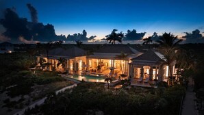 Une grande maison avec une piscine, de nombreuses pièces et un espace extérieur couvert.