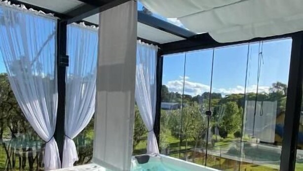 Boblebad på en træterrasse med udsigt over et grønt landskab.