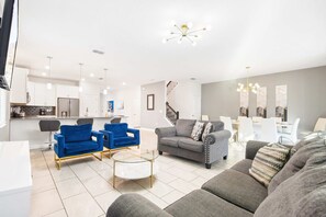 A modern living room with a sofa, armchairs, and a coffee table.