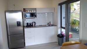 Eine kleine Küche mit Kühlschrank, Mikrowelle und Spüle.