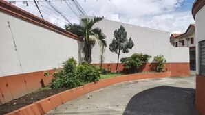 Un camino sinuoso y estrecho que lleva a un edificio con fachada blanca y naranja.