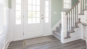 A staircase with white railings and wooden steps leading to a door with glass panels. - Coastal Catch: Walk to Boardwalk (Virginia Beach)