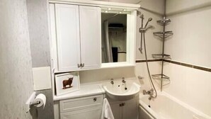 A compact bathroom with a toilet, sink, and bathtub. - NEW Super 2 Bedroom Flat in Falkirk (Falkirk)