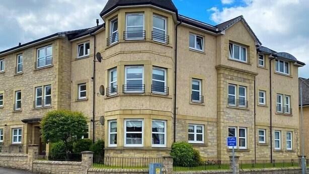A multi-story residential building with a prominent corner turret and a peaked roof. - NEW Super 2 Bedroom Flat in Falkirk (Falkirk)