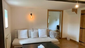 Een moderne woonkamer met een bank, een tafel en een hanglamp.