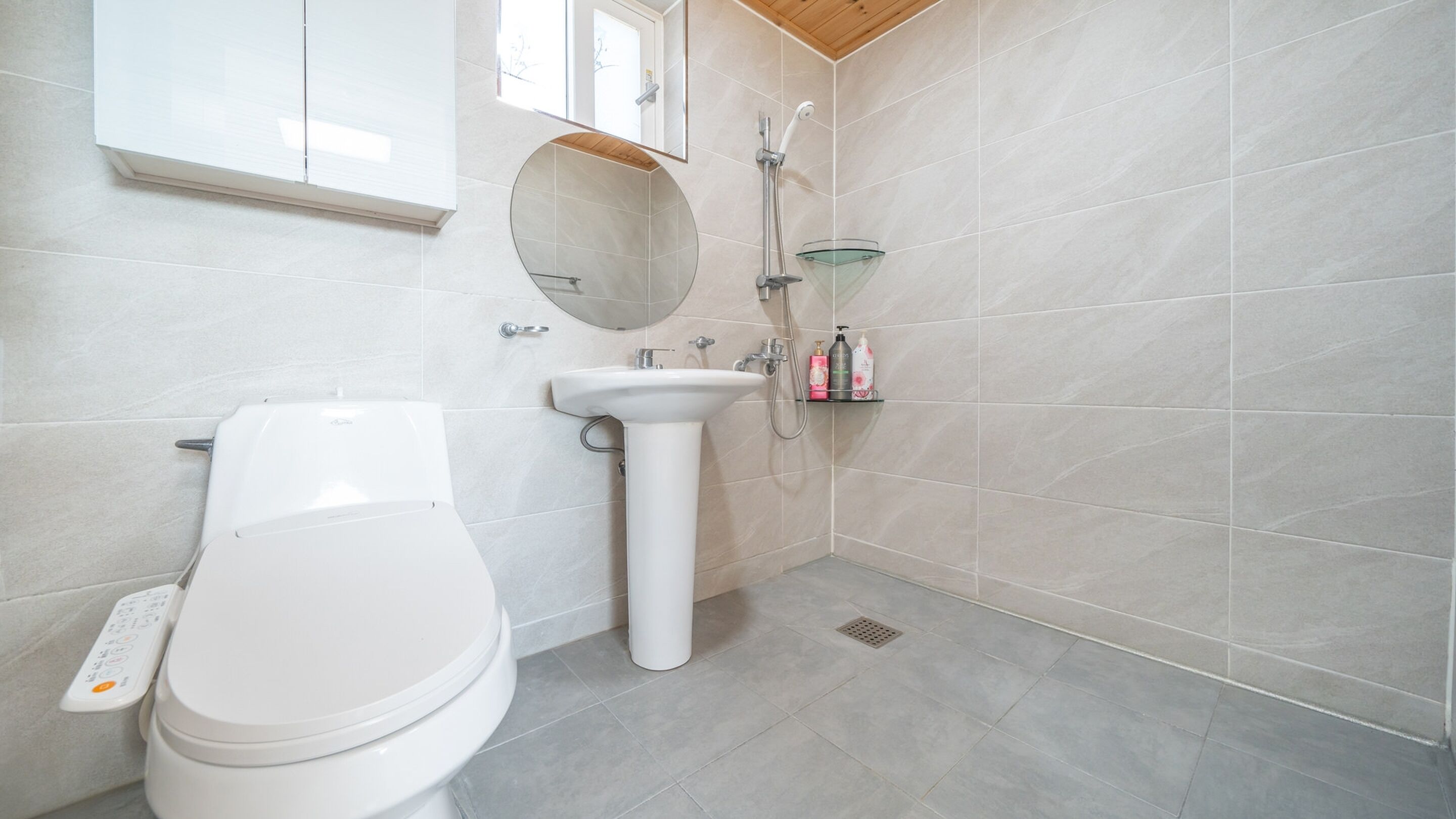 A modern bathroom with a toilet, sink, and shower.