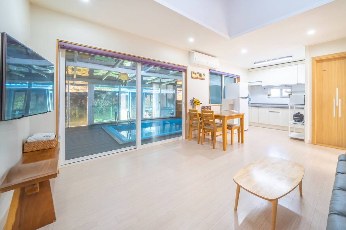 Una sala moderna con piscina, comedor y cocina.