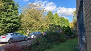 A residential area with parked cars, a stone wall, and a grassy lawn. - NEW Super 2BD Flat near Dalkeith Town Centre (Midlothian)
