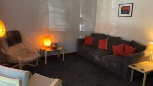 A living room with a sofa, armchairs, a small table, and a lamp. - NEW Super 2BD Flat near Dalkeith Town Centre (Midlothian)
