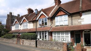 A row of terraced houses with pitched roofs, white-framed windows, and a stone wall in front. - Fantastic 2BD Victorian Apt - 4 adults and 1 child (East Sussex)