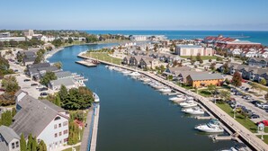 A marina with boats docked along a waterfront, surrounded by residential buildings and a large institutional building. - The Suncatcher- Steps to Lake Michigan. Pet Friendly & Fully Fenced (Sheboygan)