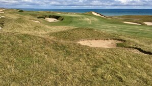 A golf course with bunkers and a view of the ocean. - The Suncatcher- Steps to Lake Michigan. Pet Friendly & Fully Fenced (Sheboygan)