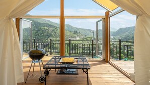 A balcony with a table, grill, and chairs, overlooking a mountainous landscape. - Gapyeong Dalmeong Pool Villa Glamping (Gapyeong)