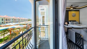 A balcony with a view of a hotel building and a colorful play area. - Le Palmier Phu Quoc Hotel (Phu Quoc)