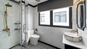 A modern bathroom with a glass-enclosed shower, a white toilet, and a vanity with a sink. - Le Palmier Phu Quoc Hotel (Phu Quoc)