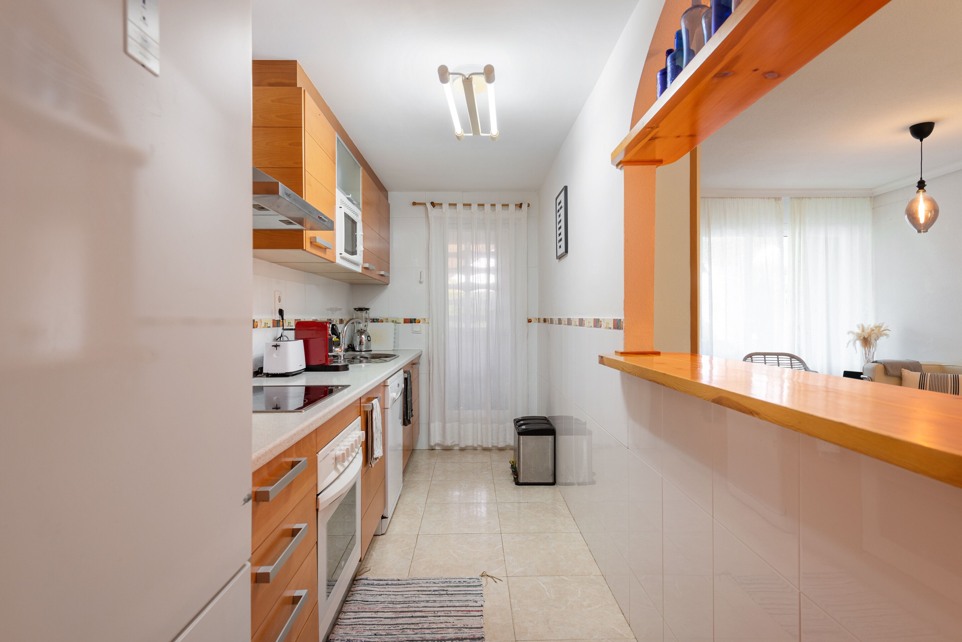 Une cuisine moderne avec des meubles en bois, un évier en acier inoxydable et un four encastré.