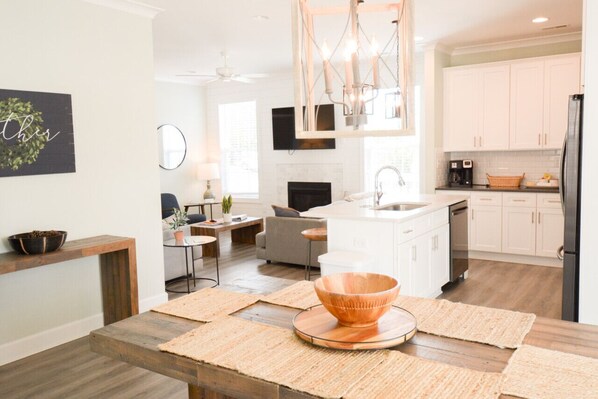 A modern kitchen with a central island, white cabinetry, and a black refrigerator.