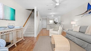 Un grand espace de vie comprenant un escalier, un coin repas et une cuisine.