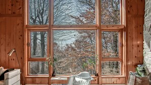 A room with large windows, a white chair, a small table, and a radiator. - 3 Br: N Westridge 222-7 Alpenglow: 3BR,2 Bath (Snowshoe)