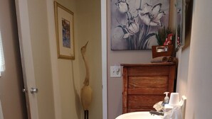Ein Badezimmer mit Toilette, Waschbecken und einem Blumengemälde an der Wand.