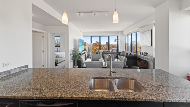 A modern kitchen with granite countertops, a double sink, and pendant lighting. - "Faith of Evanston" 180°view, 2BDR +2Bath Urban luxury (Evanston)