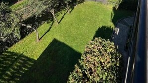 A residential area with a house, a well-maintained lawn, and a clear blue sky. - Gartenparadies Apartment  in Urbar (Urbar)