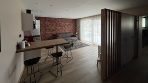 A modern living space with a kitchen, dining area, and seating area.