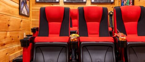 A row of red and black cinema-style seats with a filmstrip wall art and numbered film reels above.