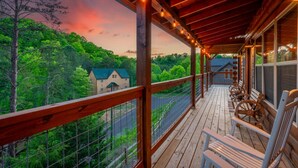 Una terraza de madera con vista a una casa y árboles.