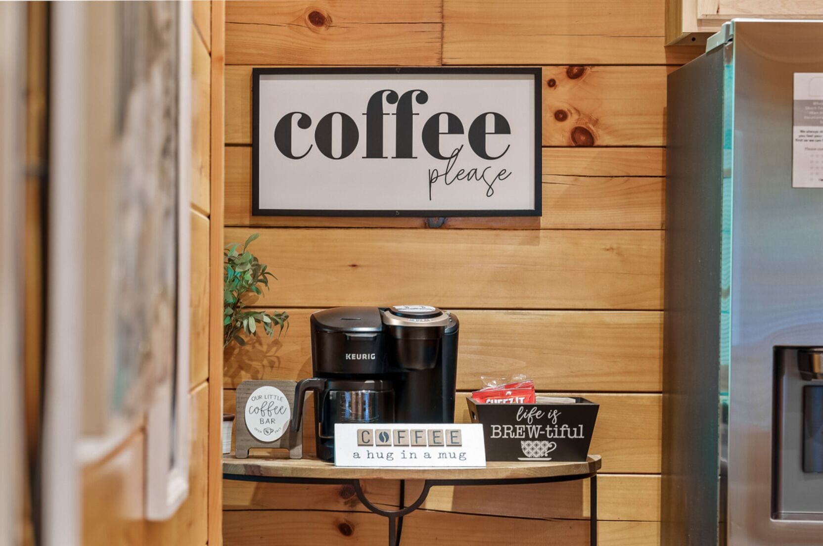 A coffee station with a sign that reads "coffee please" and a sign below stating "a hug in a mug."
