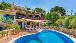 Ein Schwimmbecken mit Liegestühlen und einer Terrassenanlage.