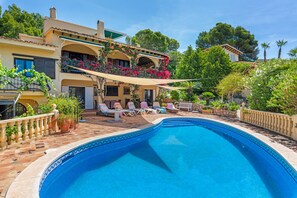 Una piscina con lettini e una terrazza.