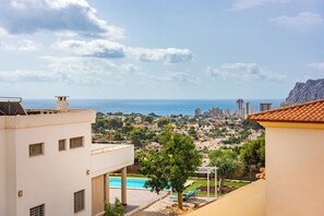 Zona residencial con piscina, vistas al mar y montañas de fondo.