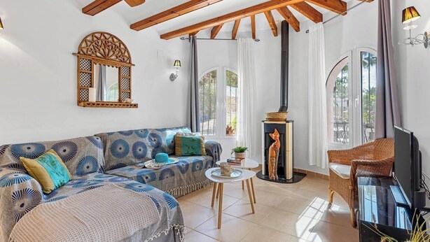 A living room with a sofa, a small table, a fireplace, and a television.