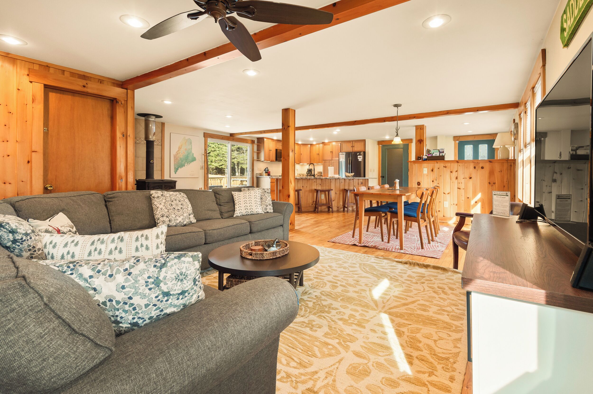 A spacious living area with a sofa, coffee table, and a dining area with chairs and a table.