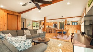A spacious living area with a sofa, coffee table, and a dining area with chairs and a table.