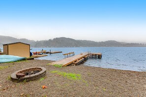 Une jetée en bois donnant sur un lac, un petit abri et un foyer.