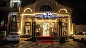 Um hotel com uma entrada imponente, tapete vermelho e uma placa que diz 'HAYAT SAMARKAND HOTEL - SPA - RESTAURANT'.