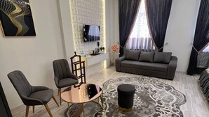 Uma sala de estar moderna com um sofá, duas poltronas, uma mesa de centro e um tapete decorativo.