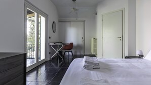 A bedroom with a bed, a desk, a chair, a radiator, and a balcony. - Villa Visconta in Naresso Inferiore (Besana in Brianza)