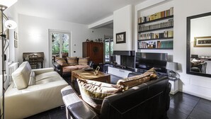 A spacious living room with a fireplace, a large bookshelf, and a piano. - Villa Visconta in Naresso Inferiore (Besana in Brianza)