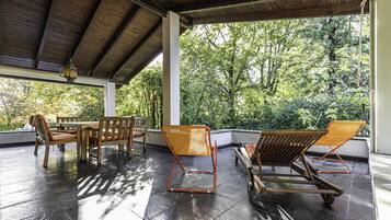 Relax in a serene outdoor space surrounded by lush greenery and a tranquil forest view.