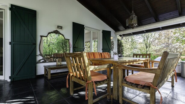 A covered outdoor dining area with wooden furniture and a large mirror. - Villa Visconta in Naresso Inferiore (Besana in Brianza)