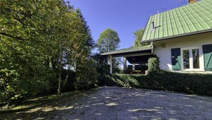 A house with a green roof, a covered porch, and a gravel driveway. - Villa Visconta in Naresso Inferiore (Besana in Brianza)