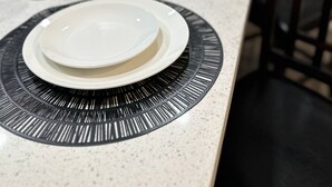 Une cuisine équipée d’un plan de travail, d’un four à micro-ondes, d’un verre à vin et d’une chaise.