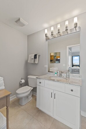 A modern bathroom with a toilet, sink, and mirror. - "Hope of Evanston" 180°view, 2BDR +2Bath Urban luxury (Evanston)