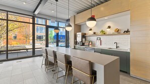 Una cocina moderna con una isla grande, taburetes de bar e iluminación colgante.