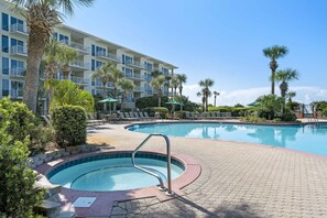 Relax by the clear blue pool surrounded by lounge chairs and umbrellas.
