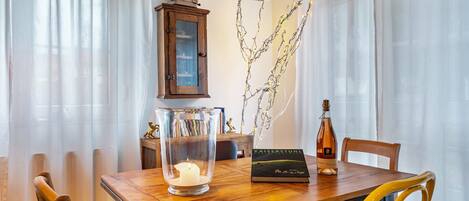 Una mesa de comedor con una vela, una botella y un libro.