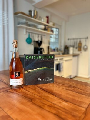 Eine Flasche Secco l'azzaro vom Schwendi und ein Buch mit dem Titel 'Kaiserstuhl' von Rainer Spaniel.